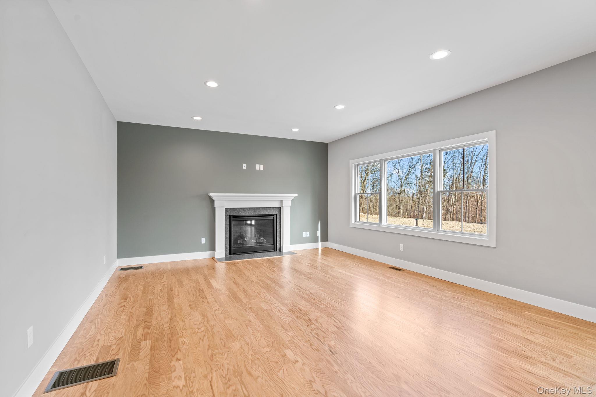 13 Harrier Ridge Drive Wallkill, NY 12589 - Photo 9 of 40 Unfurnished living room featuring light wood-type flooring, a fireplace with flush hearth, and recessed lighting