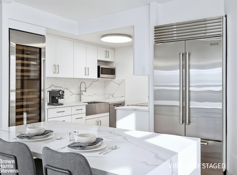 240 East 47th Street, Unit 39AB Manhattan, NY 10017 - Photo 5 of 22 a kitchen with stainless steel appliances kitchen island granite countertop a refrigerator and a stove top oven