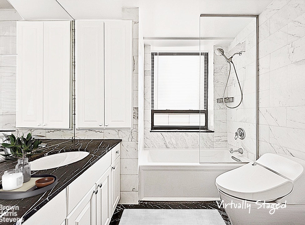 240 East 47th Street, Unit 39AB Manhattan, NY 10017 - Photo 8 of 22 a bathroom with a granite countertop sink and a mirror a bathtub