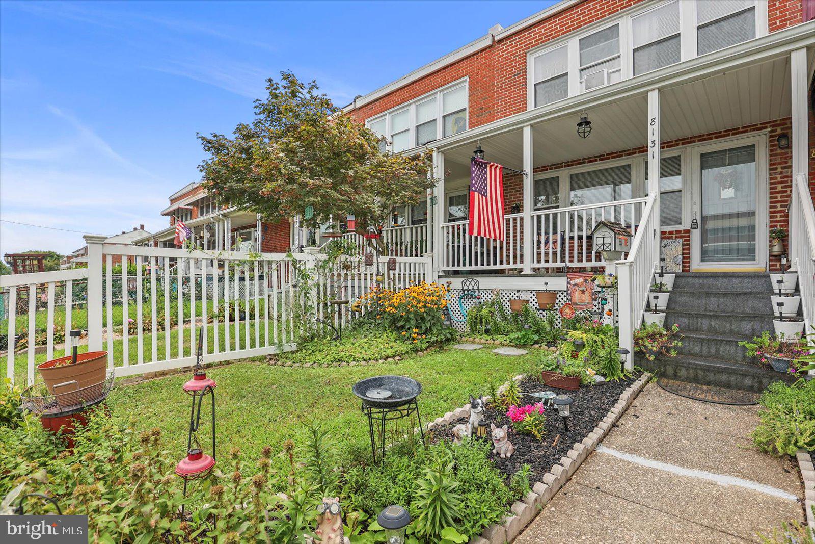8131 Del Haven Road Baltimore, MD 21222 - Photo 1 of 35 a garden with a bench in front of the house