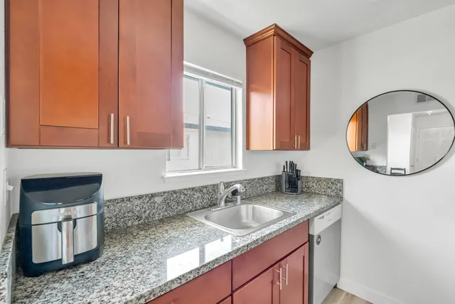 a bathroom with a granite countertop sink a mirror and vanity