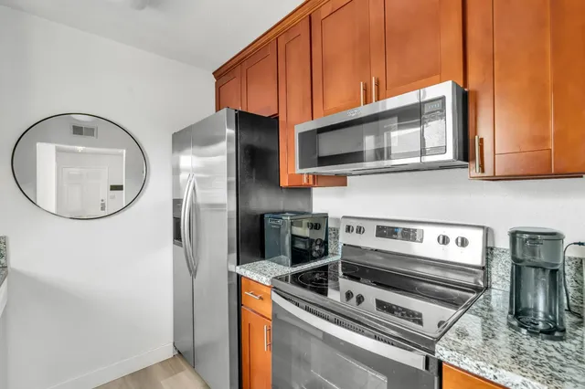 a kitchen with stainless steel appliances granite countertop a refrigerator and a stove top oven