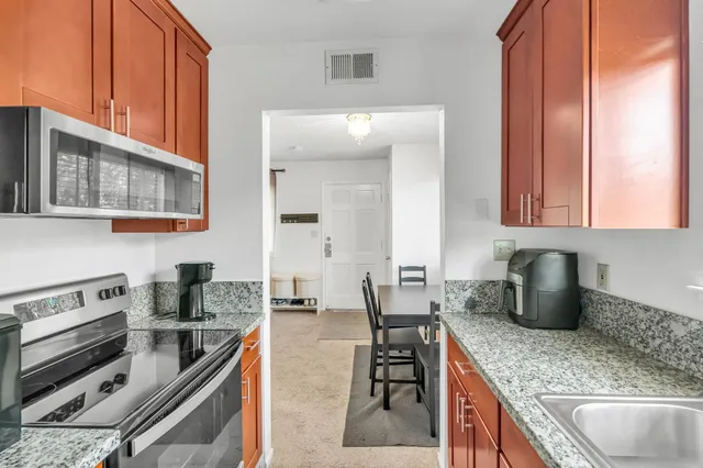 a kitchen with stainless steel appliances granite countertop a sink dishwasher stove microwave and cabinets