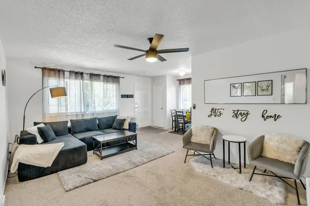 a living room with furniture and a ceiling fan