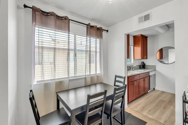 a dining room with wooden floor and furniture