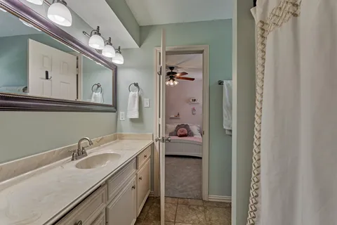 a en suite bathroom with a sink double vanity granite and a mirror