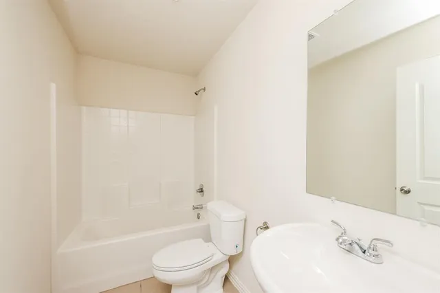 a bathroom with a bathtub shower sink vanity and toilet