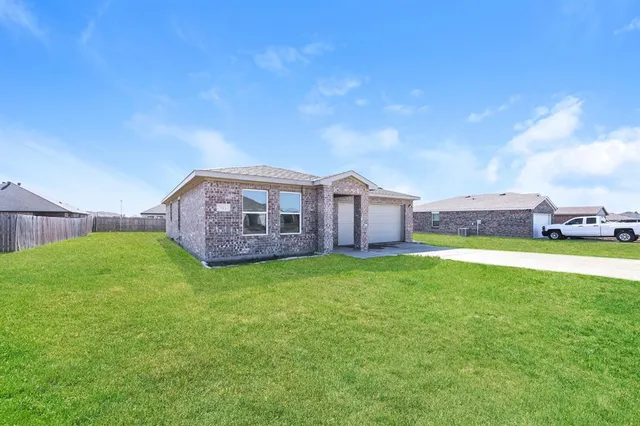 a view of a house with a big yard potted plants and large tree