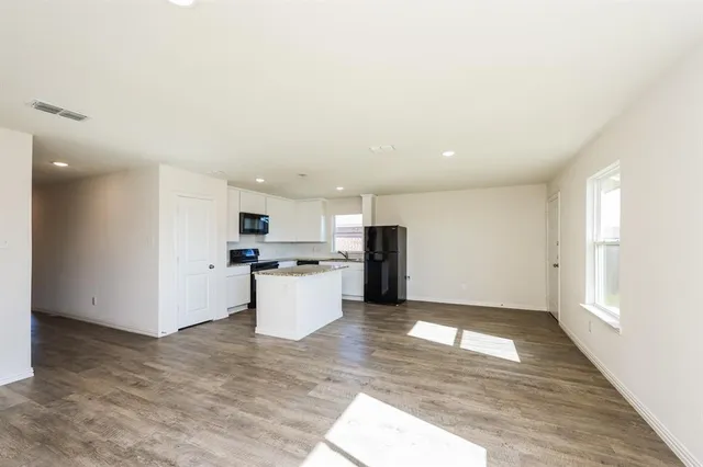 a kitchen with stainless steel appliances kitchen island sink refrigerator and microwave