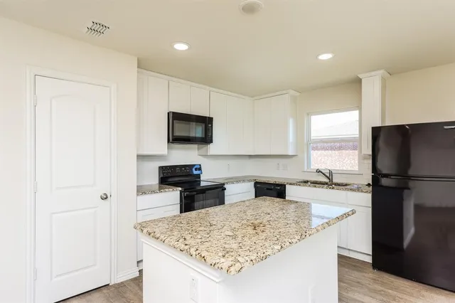 a kitchen with a refrigerator a stove a sink and a microwave