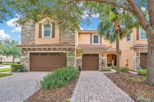 a front view of a house with yard and parking