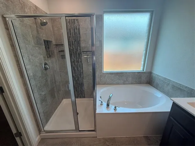 a bathroom with bathtub and shower