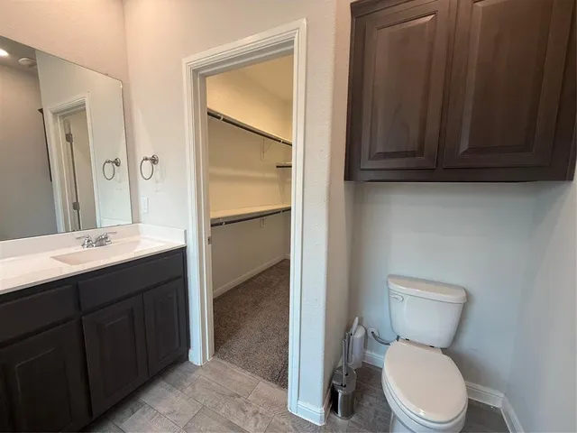 a bathroom with a toilet sink vanity and mirror