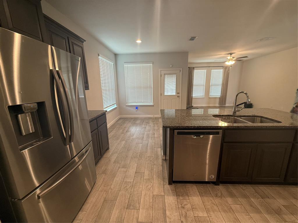 1110 Pacifica Trail Cleburne, TX 76033 - Photo 6 of 24 a kitchen with granite countertop a refrigerator sink and wooden floor