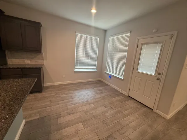 a view of an empty room with a fireplace and a window