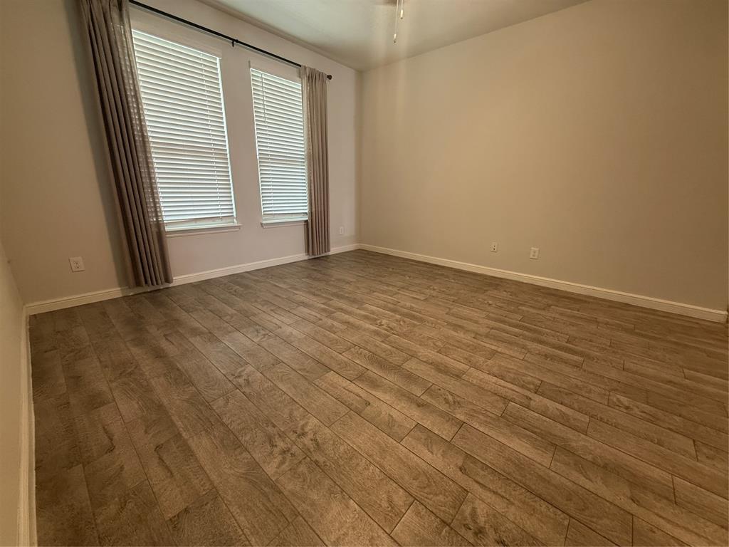 1110 Pacifica Trail Cleburne, TX 76033 - Photo 10 of 24 an empty room with wooden floor and windows