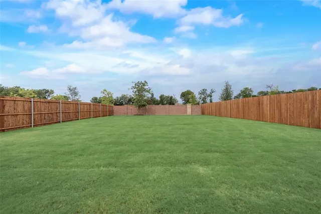 a view of yard with swimming pool and wooden fence