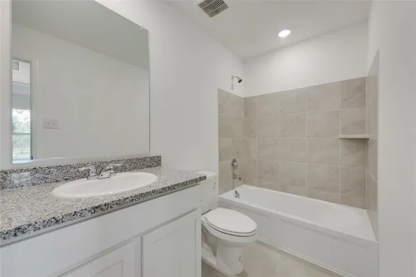 a bathroom with a granite countertop sink a toilet and bathtub