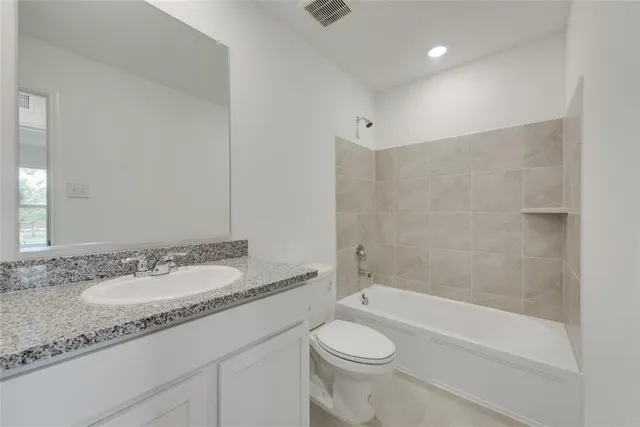 a bathroom with a granite countertop sink a toilet and bathtub