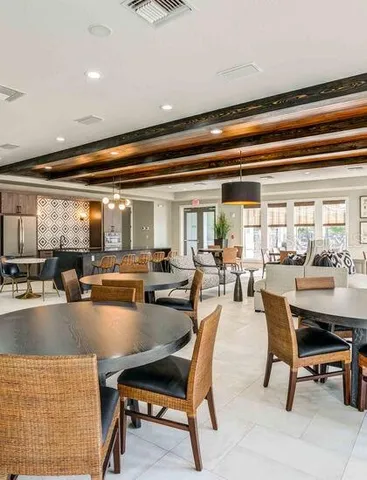 a dining hall with couches a coffee table and chairs with a large window