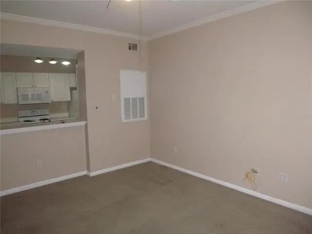 a view of a kitchen with white cabinets and wooden floor