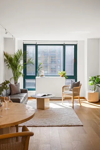 a living room with furniture a flat screen tv and a large window