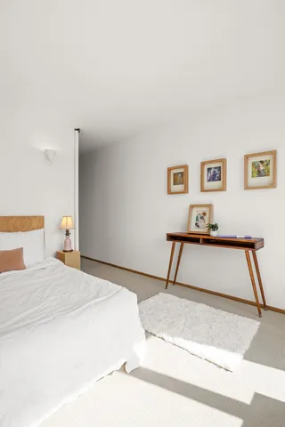 a bedroom with a bed and a painting on the wall