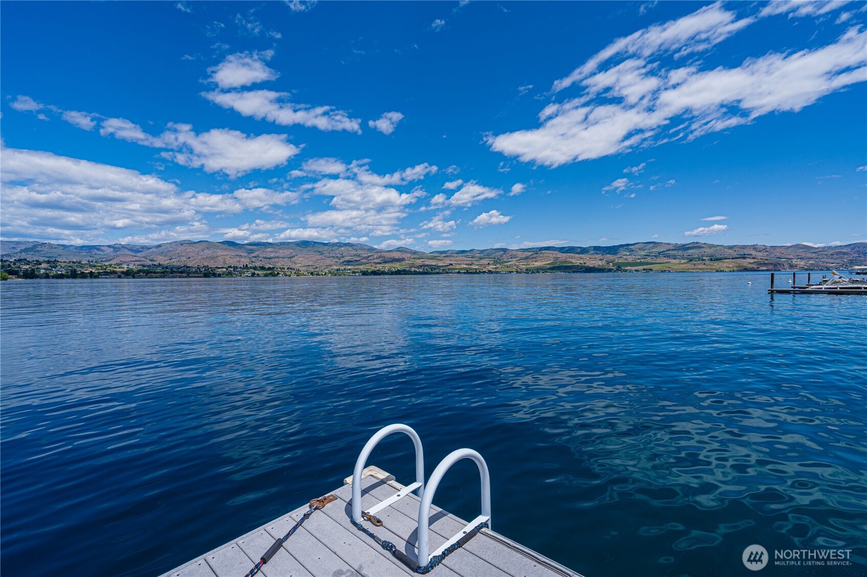 4620 South Lakeshore Road Chelan, WA 98816 - Photo 26 of 40 a view of a lake with a table and chairs in patio