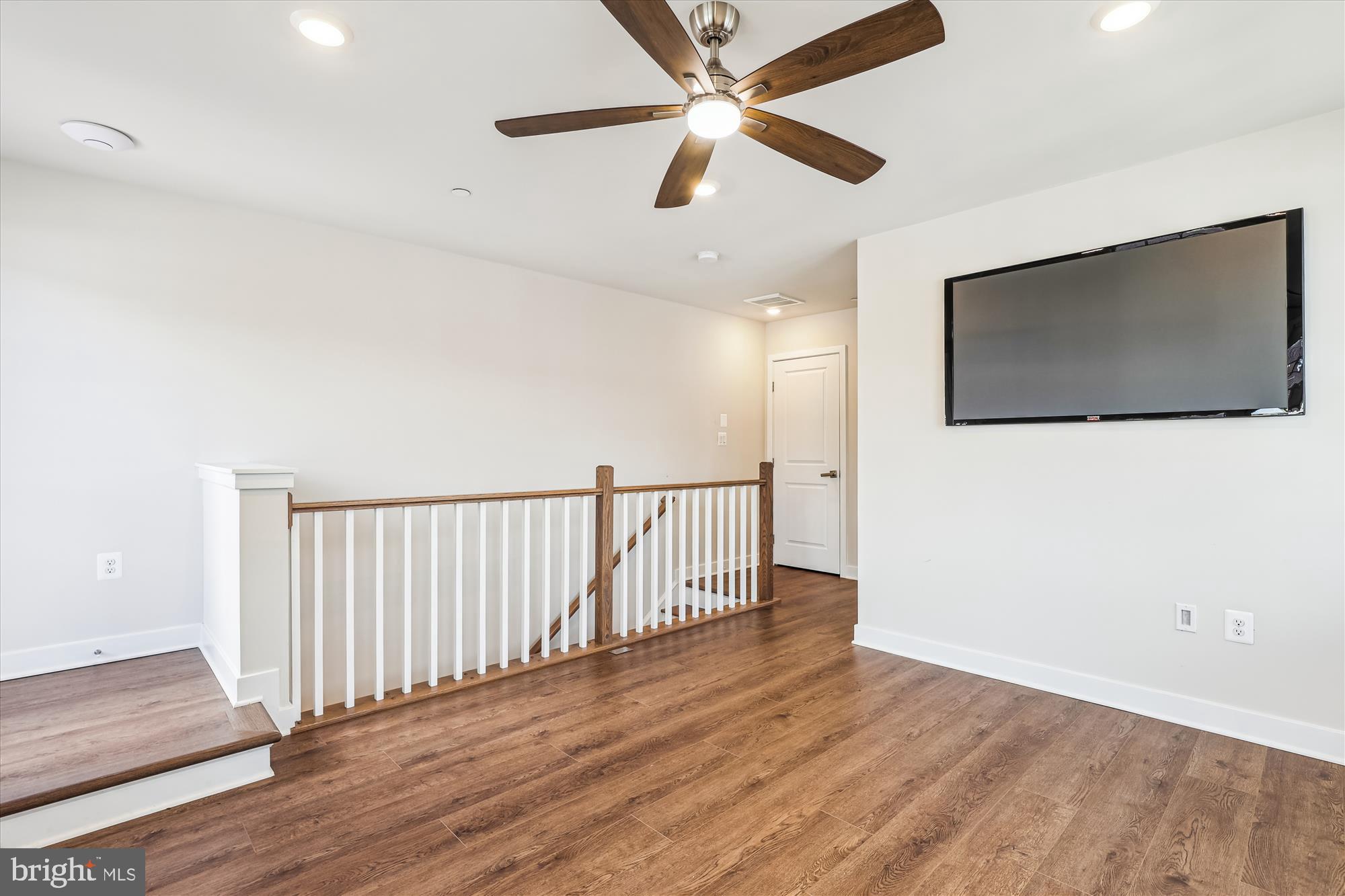 6832 General Davis Drive Northwest Washington, DC 20012 - Photo 12 of 31 an empty room with wooden floor fan and windows