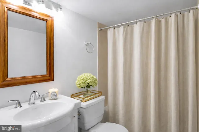 a bathroom with a sink a toilet and a mirror