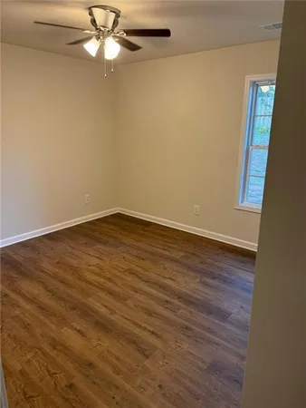 a view of a small space with wooden floor and a window