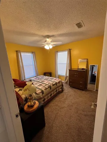 a bed sitting in a bedroom next to a window with pc on the wall