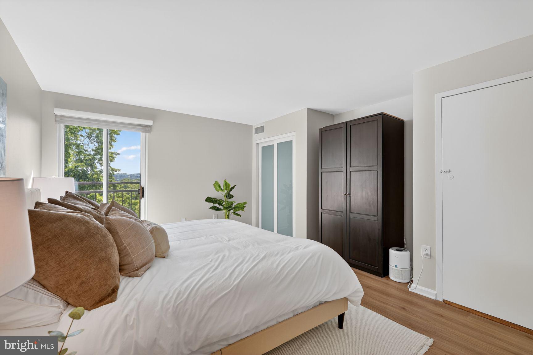 700 7th Street Southwest, Unit 734 Washington, DC 20024 - Photo 4 of 27 a bedroom with a large bed and wooden floor