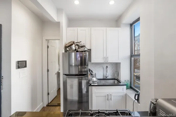 a kitchen with a refrigerator and white cabinets
