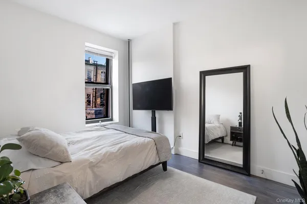 a bedroom with a bed and a flat screen tv