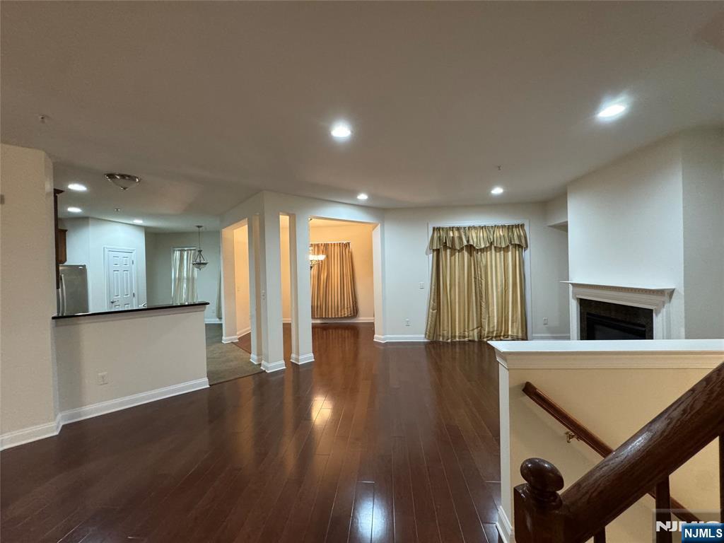 306 April Way Middletown, NJ 07748 - Photo 21 of 26 a view of an empty room with wooden floor and a kitchen