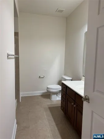 a spacious bathroom with a granite countertop sink a toilet and a shower