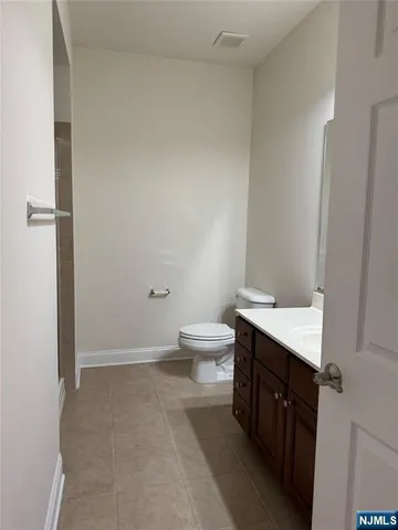 a spacious bathroom with a granite countertop sink a toilet and a shower
