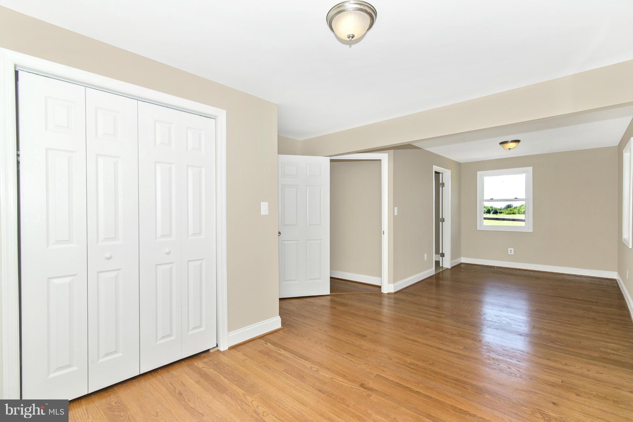18126 Beallsville Road Poolesville, MD 20837 - Photo 16 of 21 an empty room with wooden floor and windows