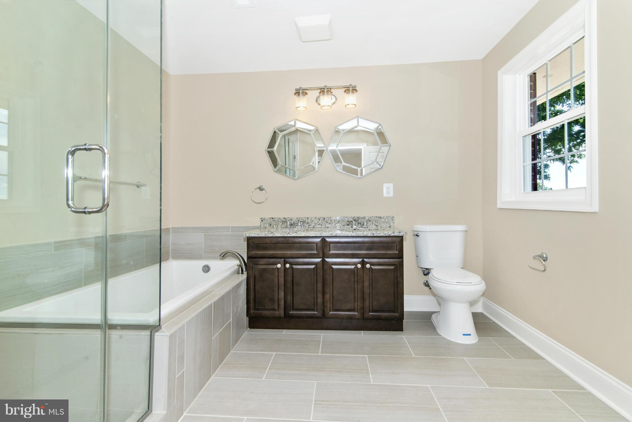 18126 Beallsville Road Poolesville, MD 20837 - Photo 17 of 21 a bathroom with a granite countertop sink a toilet and bathtub