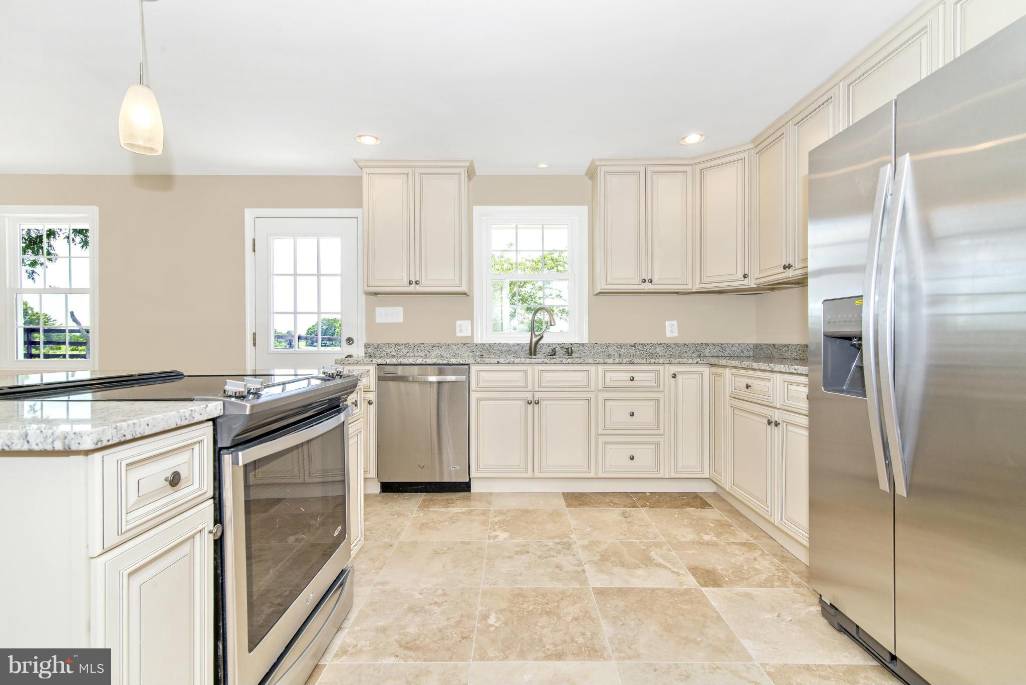 18126 Beallsville Road Poolesville, MD 20837 - Photo 10 of 21 a kitchen with white cabinets stainless steel appliances and a window