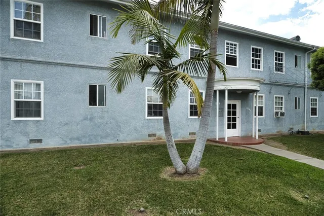 a front view of a house with a yard and trees