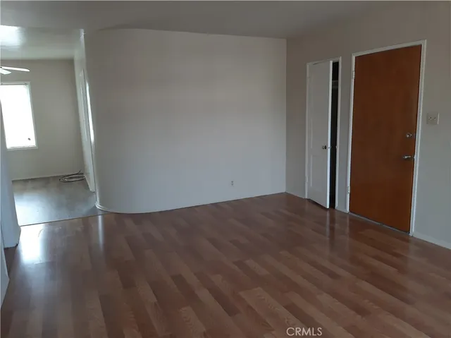 an empty room with wooden floor and closet