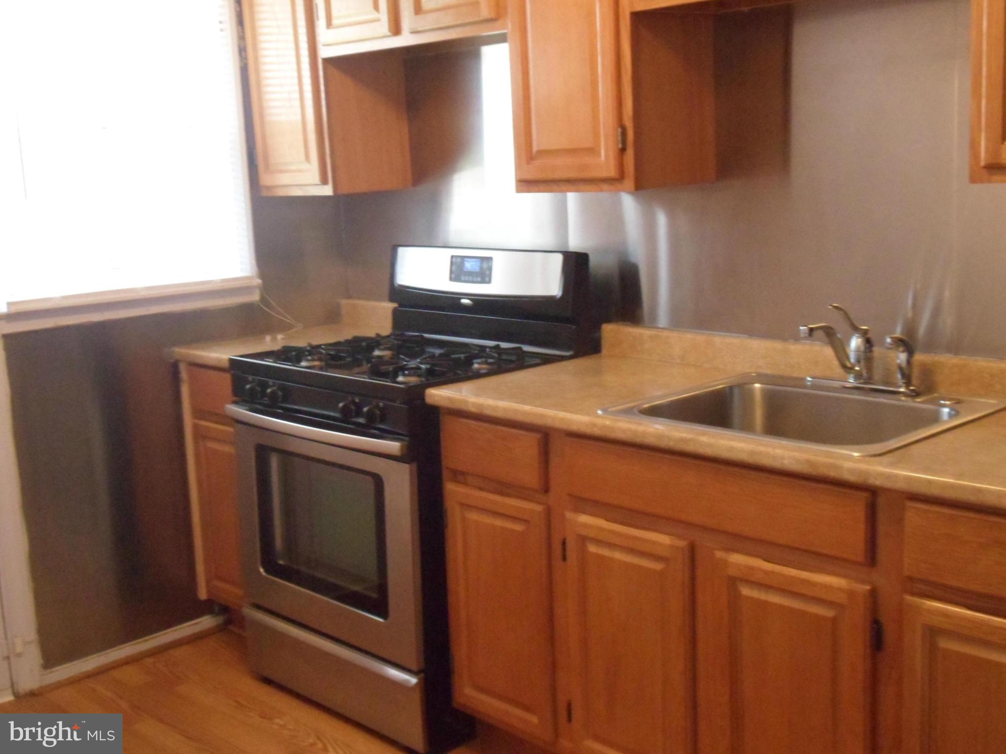 1333 Stonewood Road Baltimore, MD 21239 - Photo 11 of 30 a kitchen with granite countertop white cabinets and stainless steel appliances