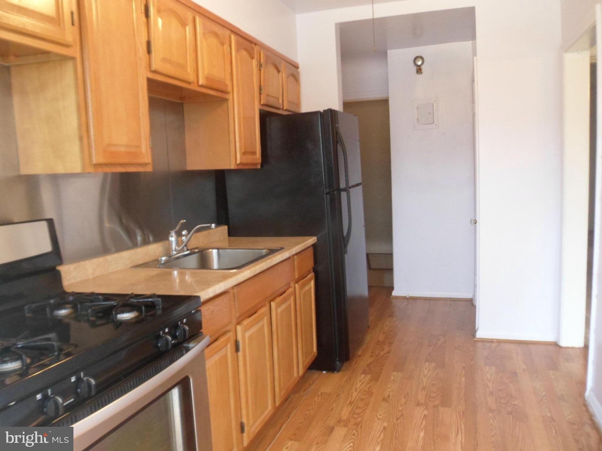1333 Stonewood Road Baltimore, MD 21239 - Photo 12 of 30 a kitchen with a sink a refrigerator and cabinets