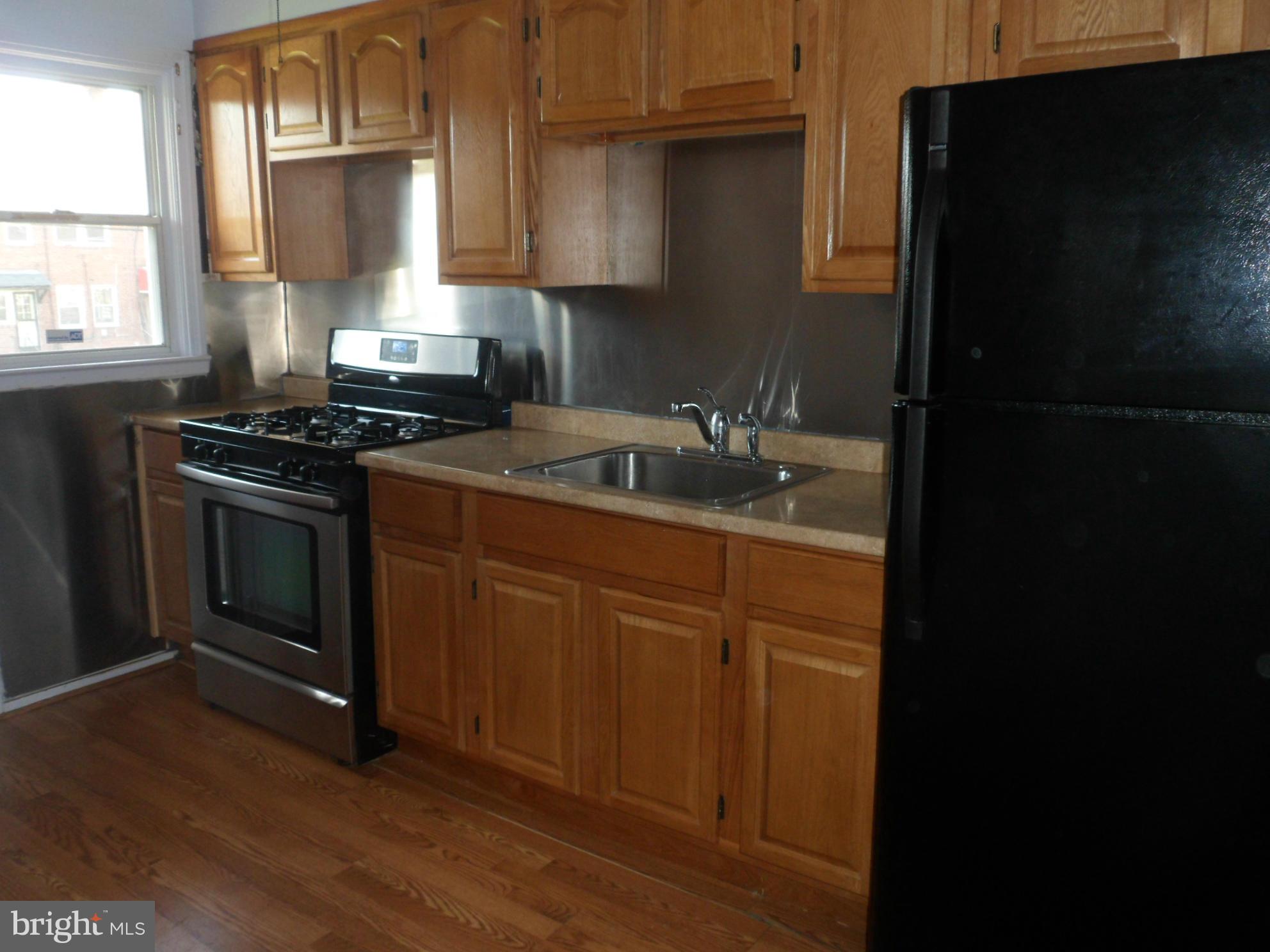 1333 Stonewood Road Baltimore, MD 21239 - Photo 10 of 30 a kitchen with granite countertop wooden cabinets and a stove top oven