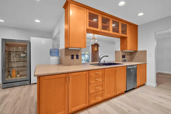 a kitchen with stainless steel appliances a refrigerator and wooden cabinets