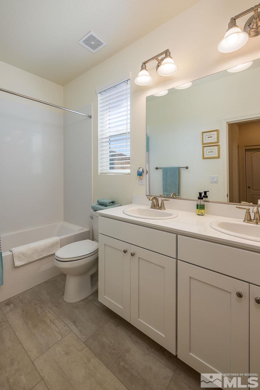 4501 High Pointe Drive Reno, NV 89521 - Photo 12 of 26 a bathroom with a toilet a sink and mirror