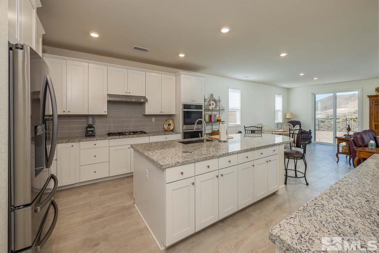 4501 High Pointe Drive Reno, NV 89521 - Photo 15 of 26 a kitchen with granite countertop white cabinets and white stainless steel appliances