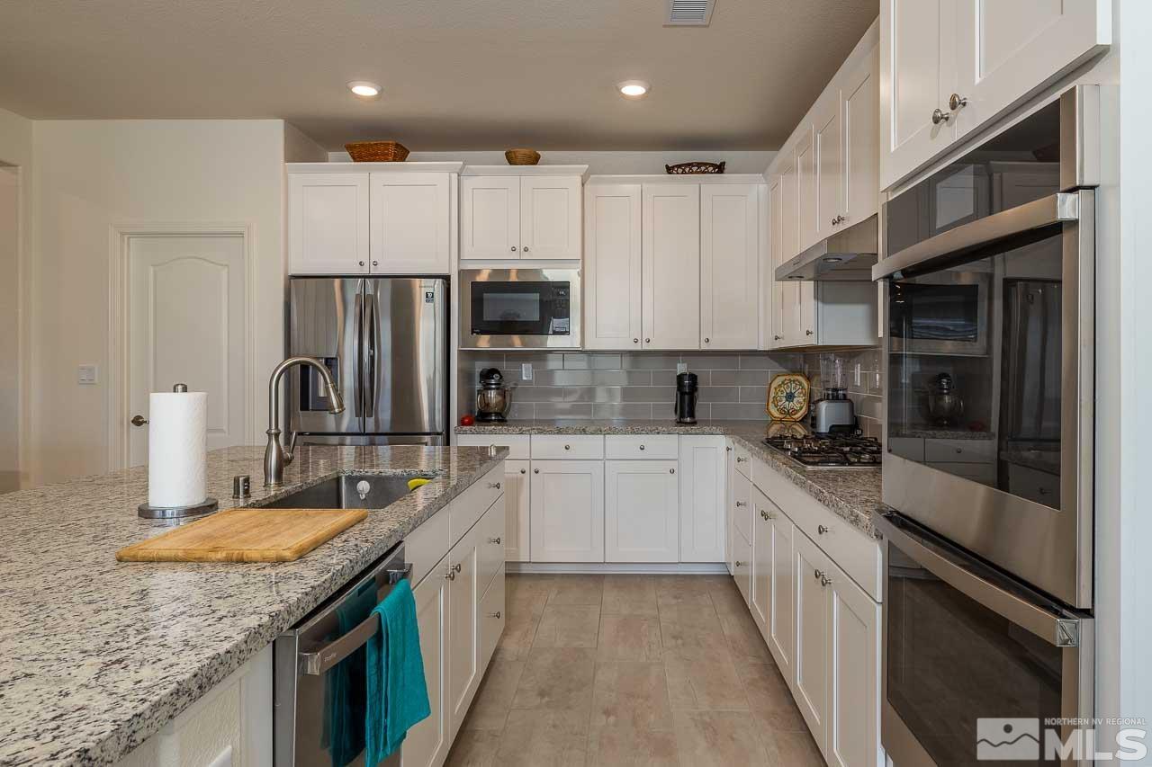 4501 High Pointe Drive Reno, NV 89521 - Photo 17 of 26 a kitchen with stainless steel appliances granite countertop a sink stove and refrigerator